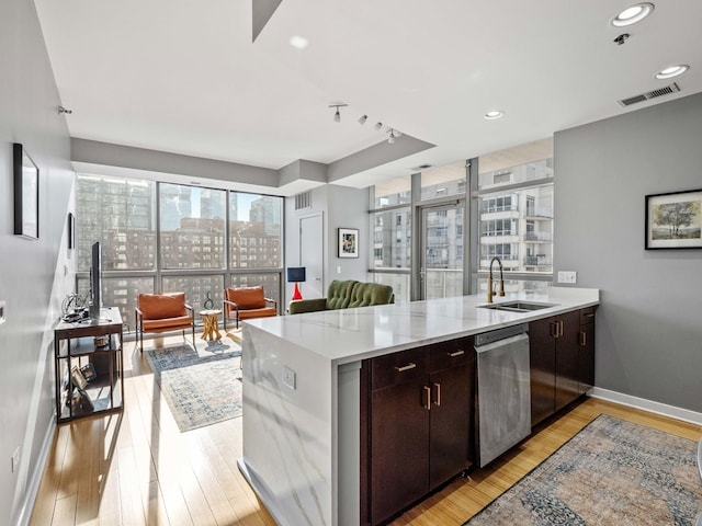 kitchen with dishwasher, sink, dark brown cabinetry, kitchen peninsula, and light hardwood / wood-style floors