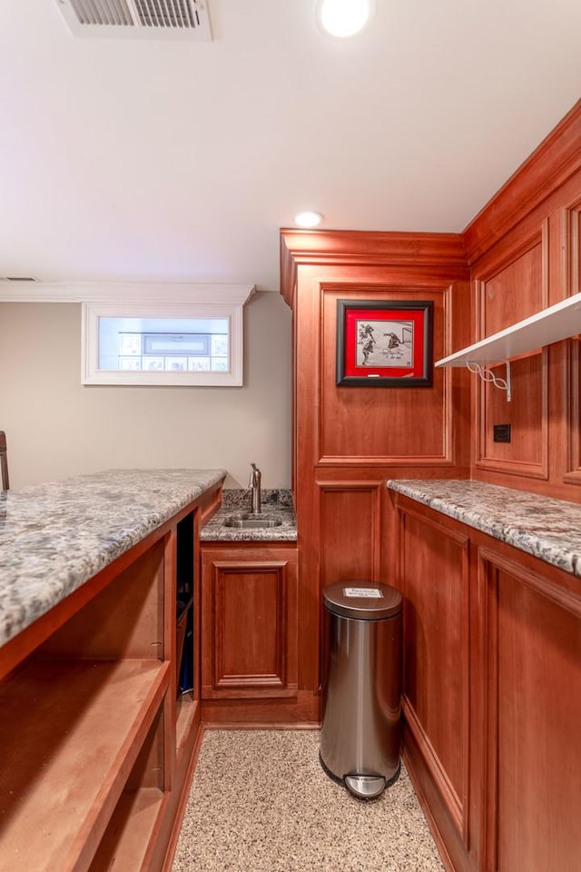 bar with light stone countertops and sink