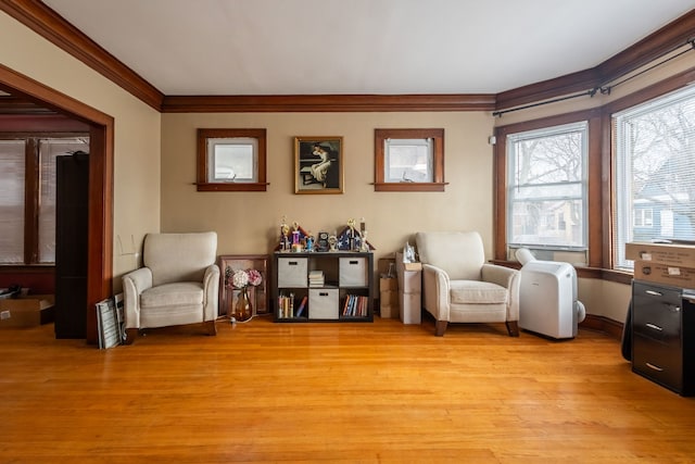 living area featuring crown molding and light wood-type flooring