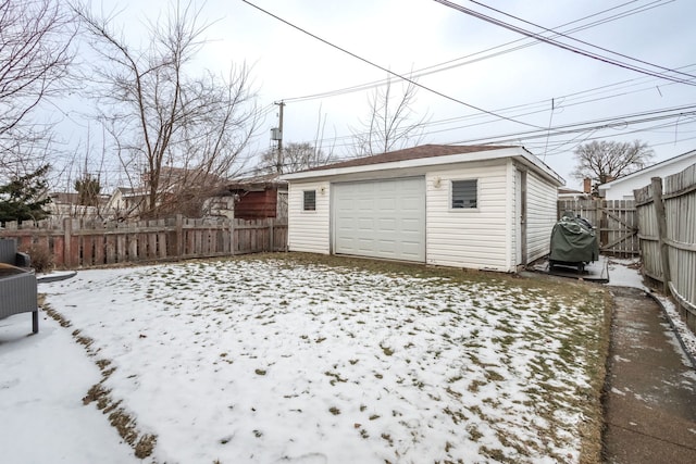 yard covered in snow featuring a garage and an outdoor structure