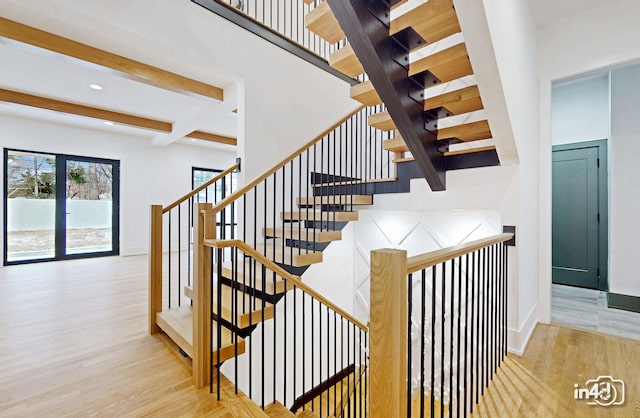 staircase featuring hardwood / wood-style flooring and beam ceiling