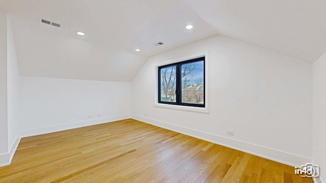 additional living space featuring vaulted ceiling and wood-type flooring