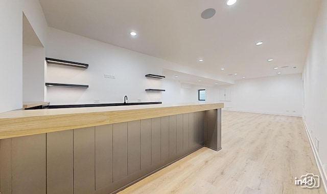 bar featuring sink and light hardwood / wood-style floors