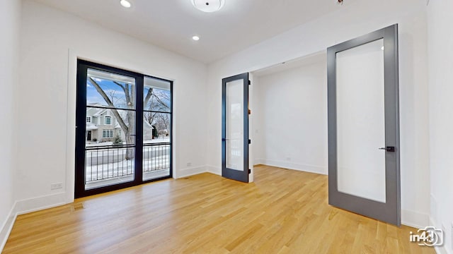 unfurnished room featuring light hardwood / wood-style floors and french doors