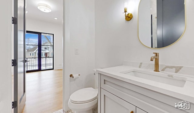 bathroom featuring vanity, hardwood / wood-style floors, and toilet