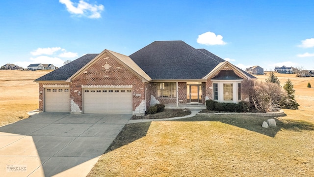 view of front of property featuring a garage, a front lawn, and a porch