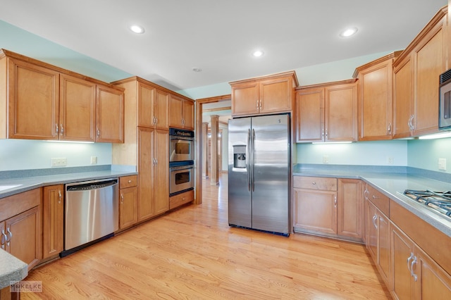 kitchen with stainless steel appliances and light hardwood / wood-style flooring