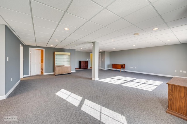 basement featuring a paneled ceiling and carpet