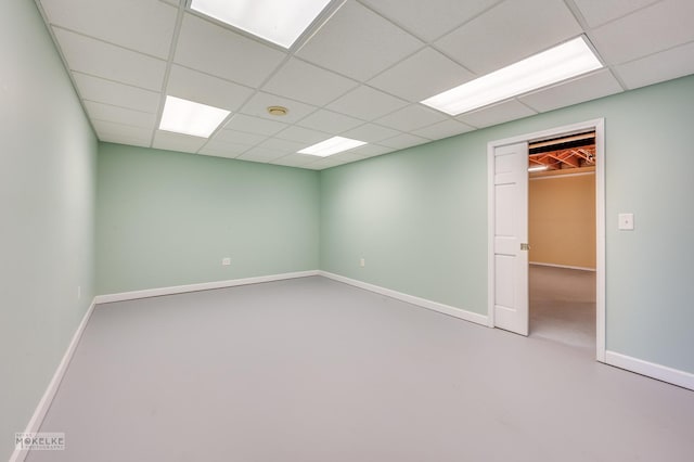 unfurnished room with a paneled ceiling and concrete flooring