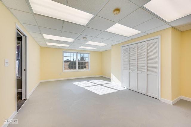 unfurnished bedroom featuring a paneled ceiling and a closet