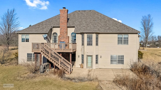 back of property with a wooden deck and a patio