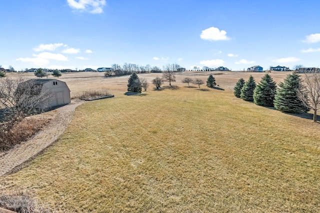 view of yard with an outbuilding and a rural view