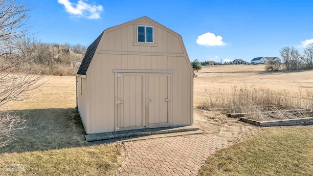 view of outbuilding with a rural view and a lawn