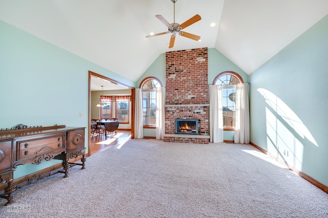 carpeted living room featuring ceiling fan, plenty of natural light, high vaulted ceiling, and a fireplace