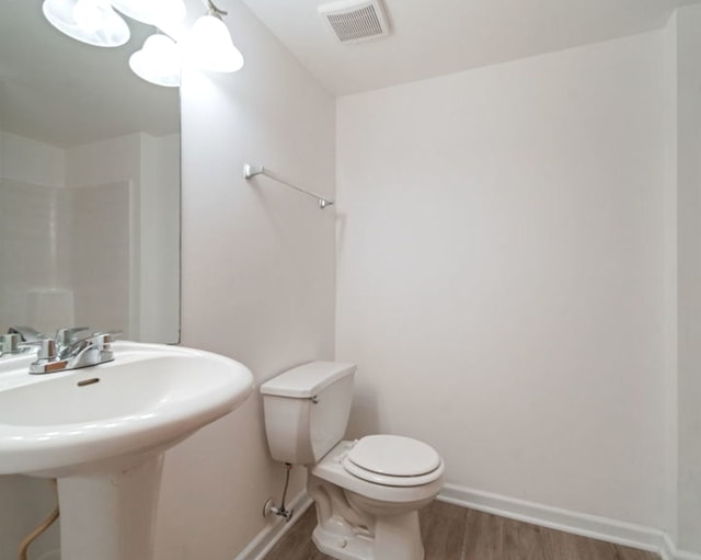 bathroom with hardwood / wood-style flooring, sink, and toilet