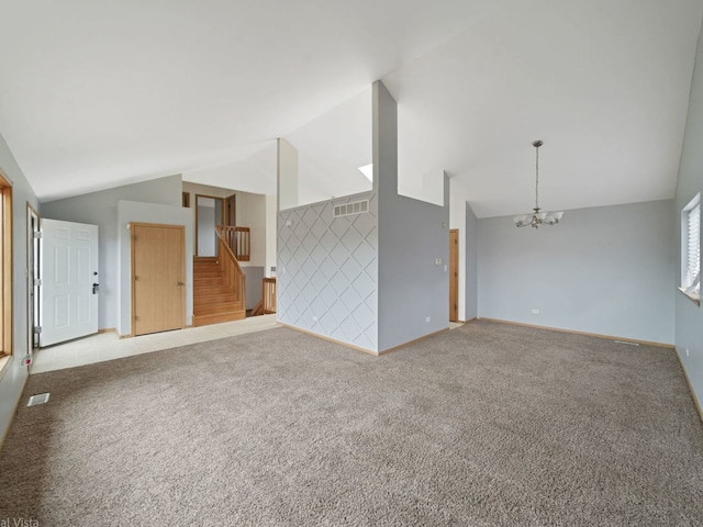 unfurnished living room featuring carpet, a notable chandelier, and high vaulted ceiling