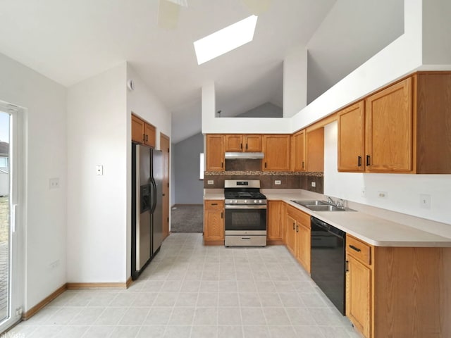 kitchen with sink, backsplash, lofted ceiling with skylight, and appliances with stainless steel finishes