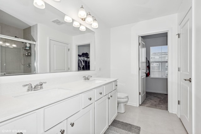 bathroom featuring vanity, tile patterned flooring, toilet, and walk in shower