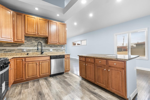 kitchen featuring stove, sink, stainless steel dishwasher, and plenty of natural light