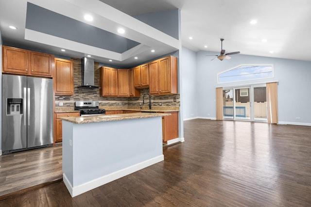 kitchen featuring appliances with stainless steel finishes, dark hardwood / wood-style floors, tasteful backsplash, ceiling fan, and wall chimney exhaust hood