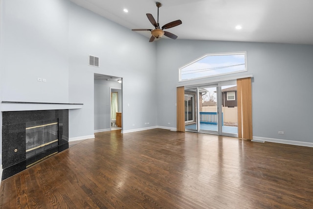 unfurnished living room with a tiled fireplace, high vaulted ceiling, dark wood-type flooring, and ceiling fan