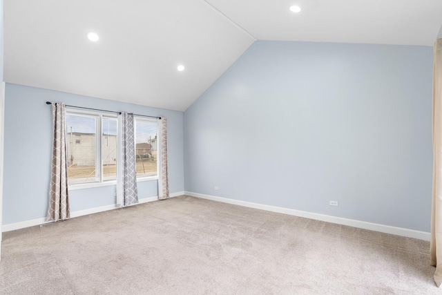 unfurnished room featuring light colored carpet and vaulted ceiling