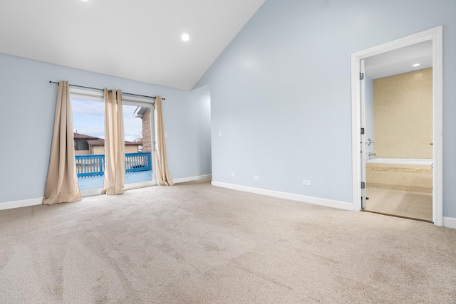 carpeted empty room with high vaulted ceiling