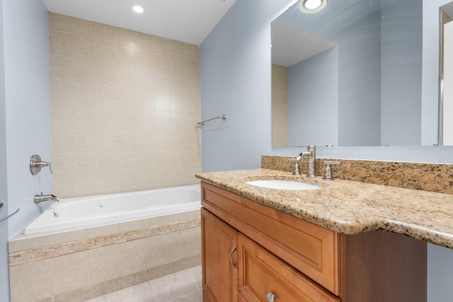 bathroom with vanity, tiled tub, and tile patterned flooring