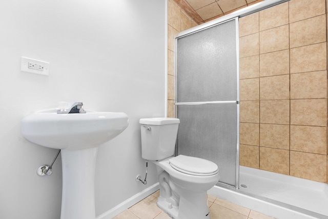 bathroom with tile patterned flooring, sink, a shower with shower door, and toilet