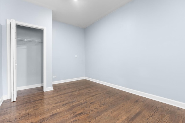 unfurnished bedroom with dark hardwood / wood-style flooring and a closet