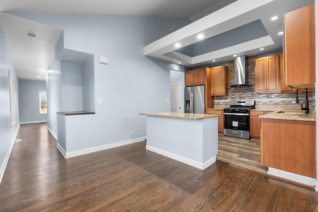 kitchen featuring a kitchen island, appliances with stainless steel finishes, sink, light stone counters, and wall chimney range hood