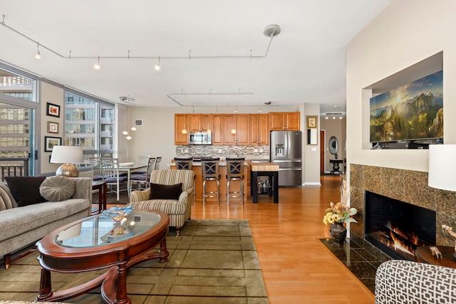 living room with light hardwood / wood-style floors and a tile fireplace