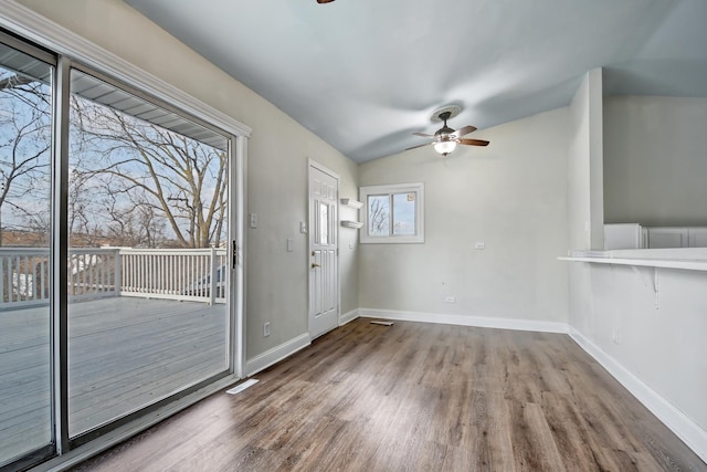 interior space featuring ceiling fan, wood-type flooring, and vaulted ceiling