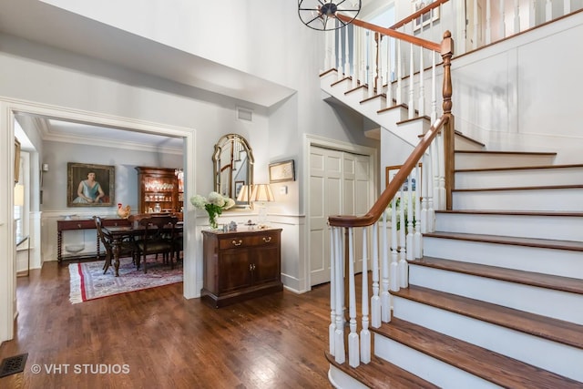 stairs with ornamental molding and hardwood / wood-style floors