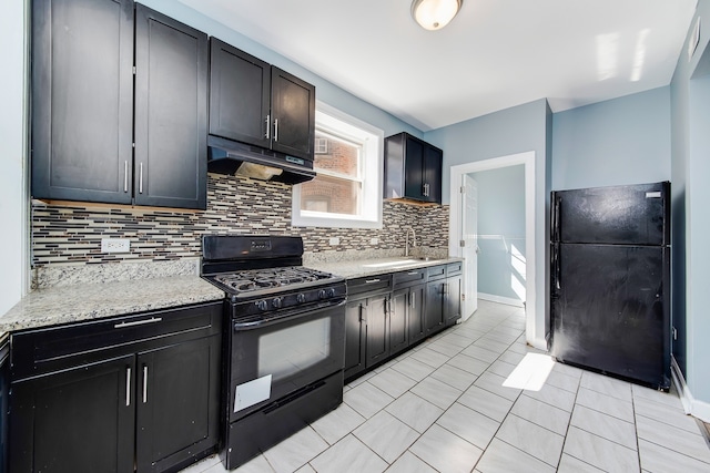 kitchen with sink, decorative backsplash, light tile patterned floors, light stone counters, and black appliances