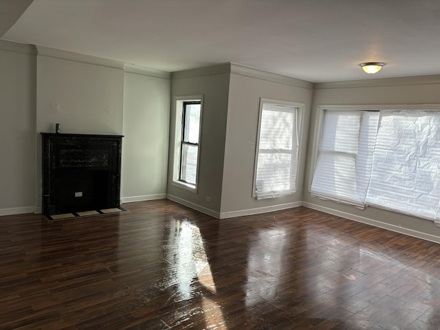 unfurnished living room with ornamental molding and dark hardwood / wood-style flooring