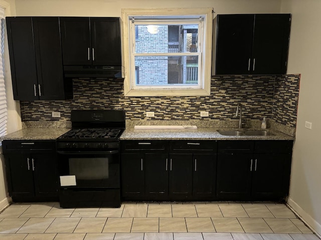 kitchen with backsplash, sink, light stone counters, and black gas range oven