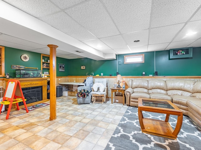 living room featuring wooden walls and a drop ceiling