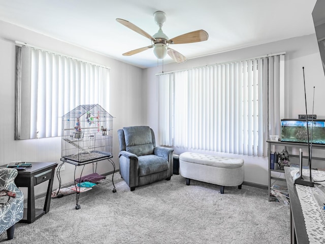 living area with a healthy amount of sunlight, light carpet, and ceiling fan