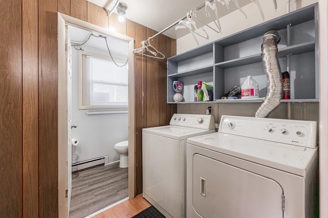 washroom featuring washing machine and dryer, light hardwood / wood-style flooring, and a baseboard radiator