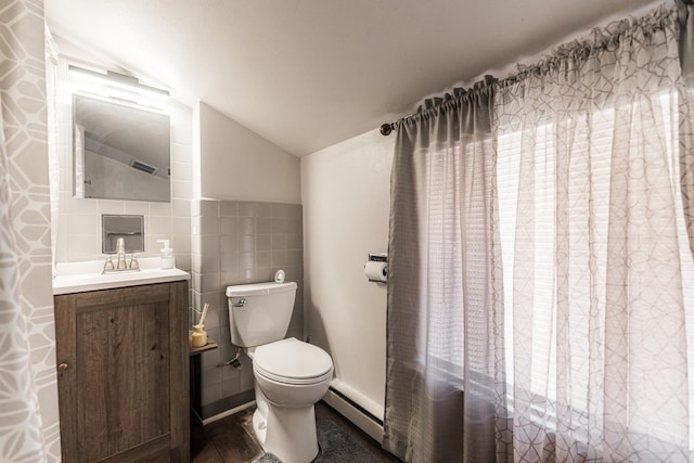 bathroom featuring tile walls, vanity, vaulted ceiling, and toilet