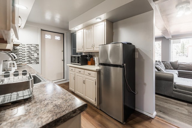 kitchen featuring appliances with stainless steel finishes, dark hardwood / wood-style flooring, and tasteful backsplash