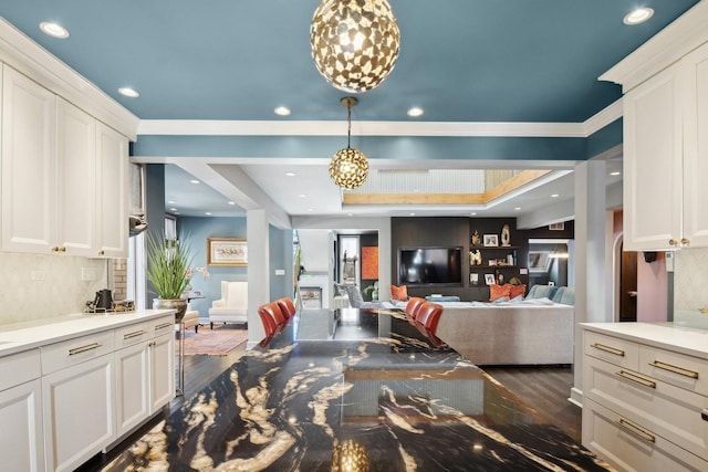 kitchen featuring tasteful backsplash, white cabinetry, hanging light fixtures, and dark hardwood / wood-style floors