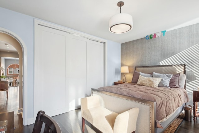 bedroom with dark hardwood / wood-style floors and a closet