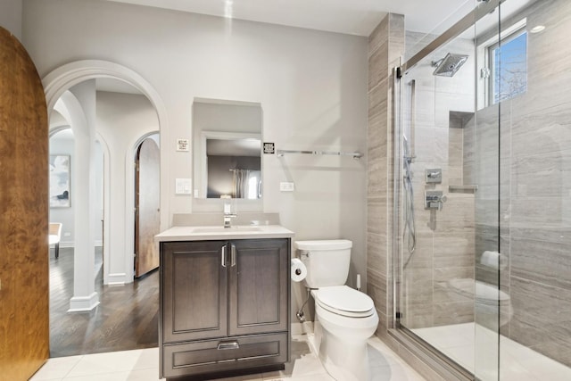 bathroom featuring vanity, tile patterned floors, toilet, and walk in shower