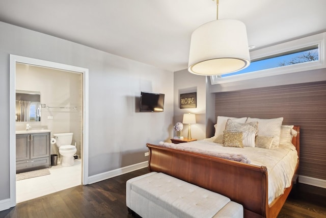 bedroom featuring ensuite bathroom, sink, and dark hardwood / wood-style flooring