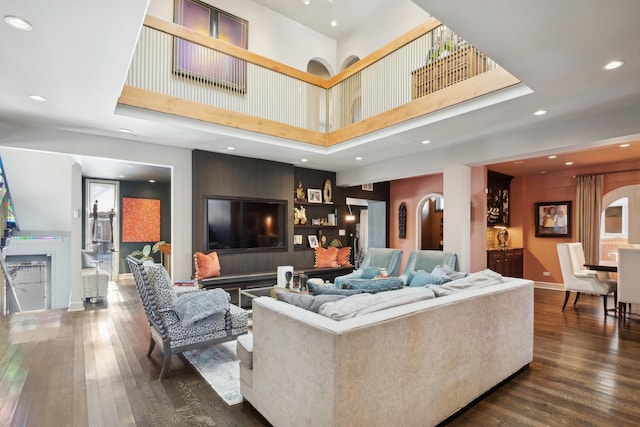 living room with a high ceiling and dark hardwood / wood-style floors