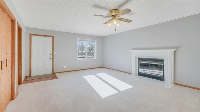 unfurnished living room featuring light carpet, a textured ceiling, and a fireplace with flush hearth