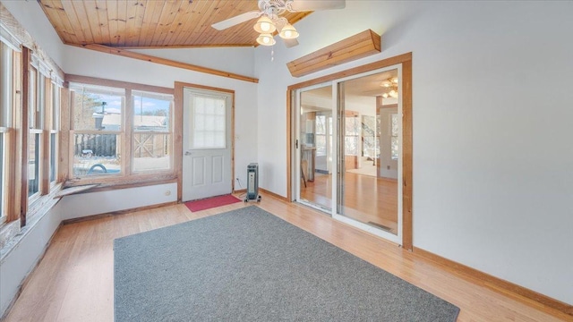 unfurnished sunroom with vaulted ceiling, ceiling fan, wooden ceiling, and a healthy amount of sunlight