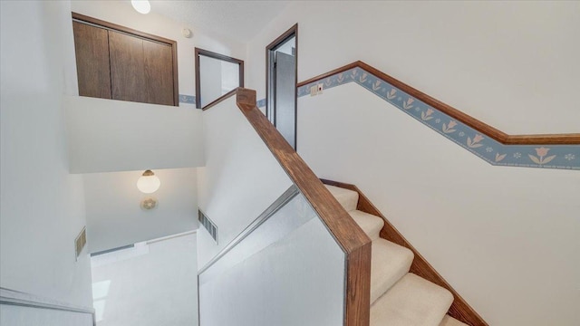 staircase with visible vents and baseboards